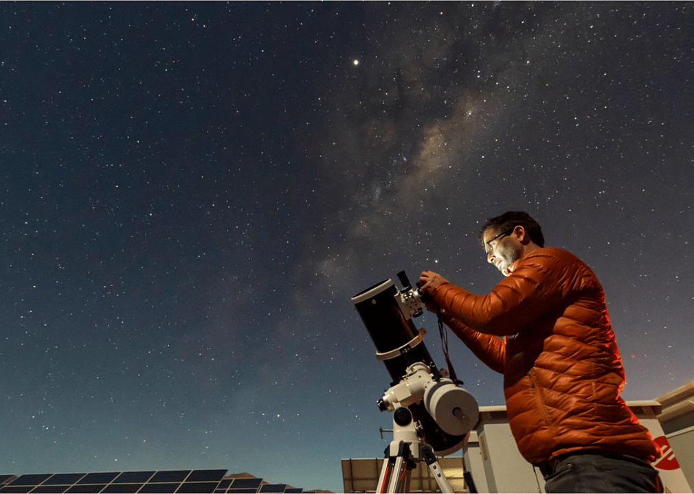 A man sets up a high-powered telescope.