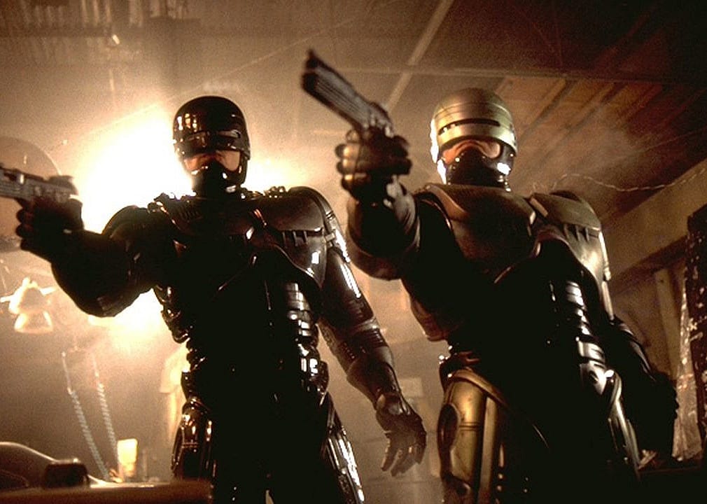 Two robot policemen point guns.