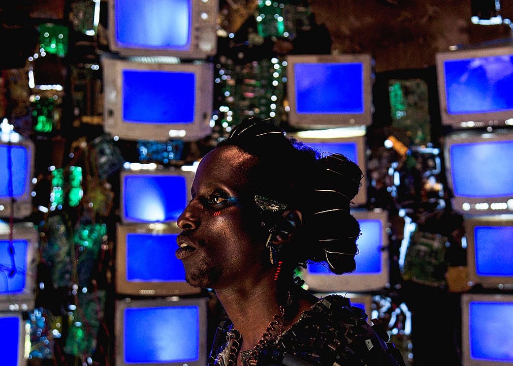 A person in front of a wall full of blue screens.
