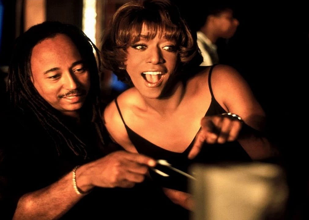 A man and a woman sit closely together looking surprised at something.