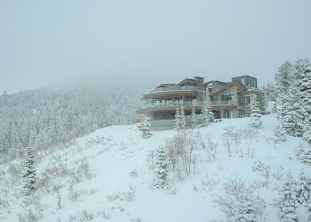 Snow covered hillside and exterior of mansion in an exclusive Park City development that was location for the show Mountainhead.