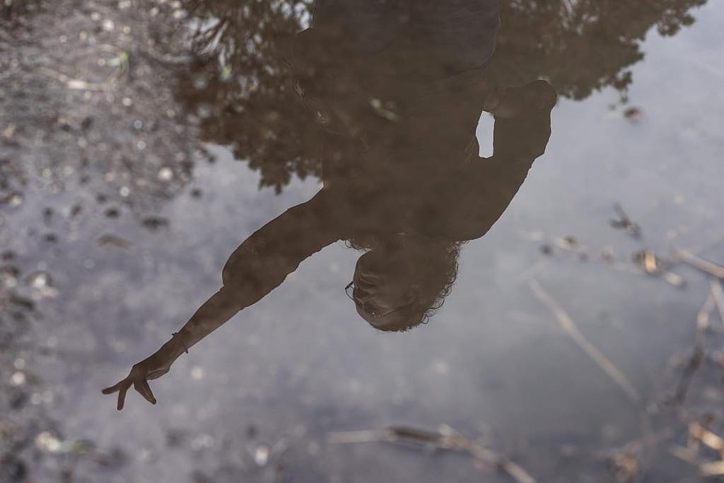 Ana Zimmerman, reflected in standing water, near the site of her old home in Shoreham Road.