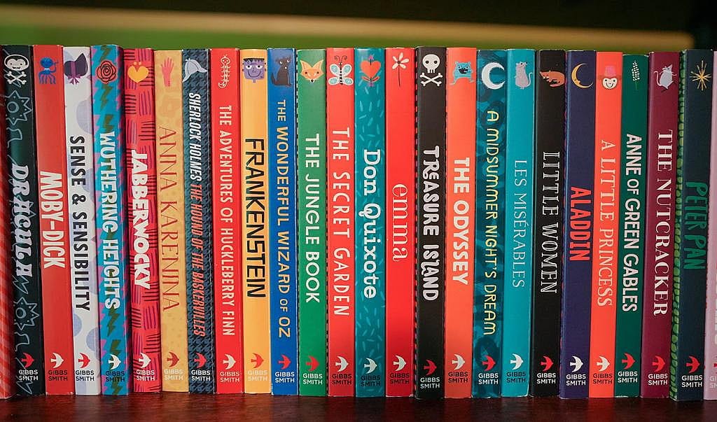 Colorful board books for children lined up on a bookshelf displayed in home of author Jennifer Adams.