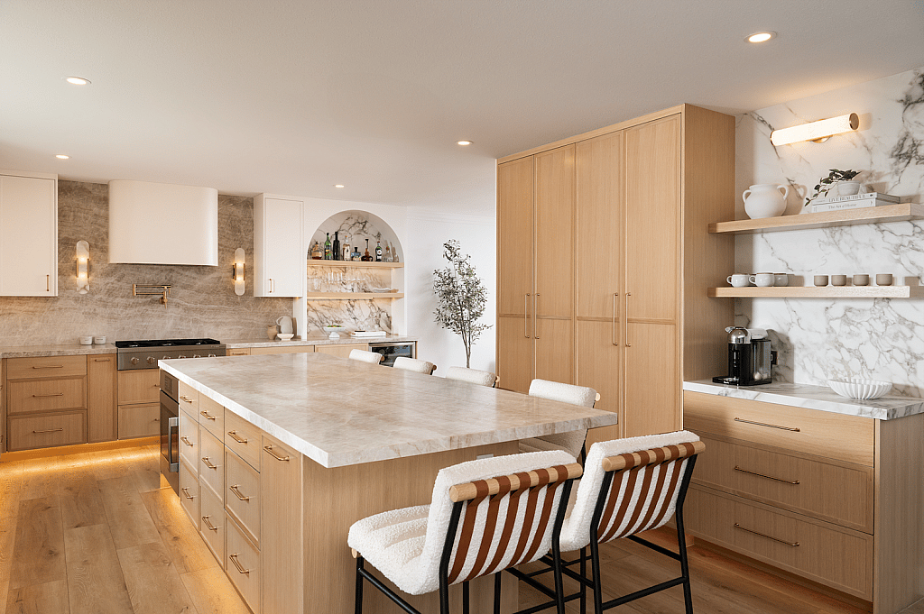 A kitchen with built-in blond wood cabinet storage and organization on one side wall with additional drawers under the center island and under the range.