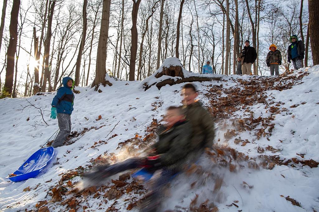 Students go sledding in the morning at Nature’s Gift Microschool at Nameless Creek in Greenfield, Ind., on Dec. 5, 2025. 