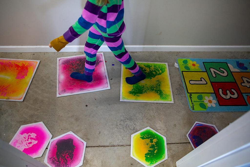 A Nature’s Gift student step on colorful floor tiles in the microschool’s main building.