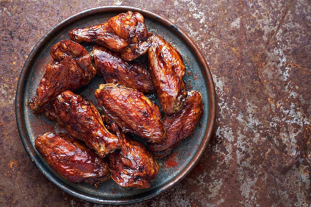 A plate of teriyaki sauce-coated chicken wings.