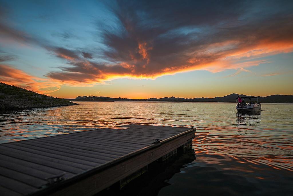 View of a boat reaching a dock during sunset in Lake Pleasant in Arizona.