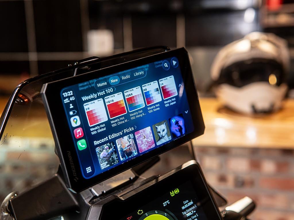 Screen display on motorcycle with music display shows tech interface that connects to phone.