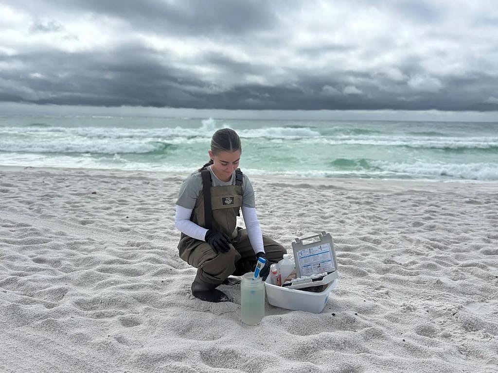 Natalie Larsen, a member of the Vibrio surveillance research team, gathers seawaters samples from Florida’s Pensacola Beach to test for vulnificus and other bacteria.