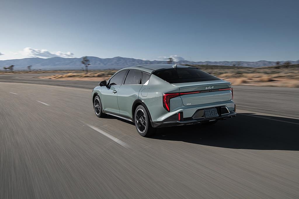 A rear view of the 2026 Kia K4 car on the road.