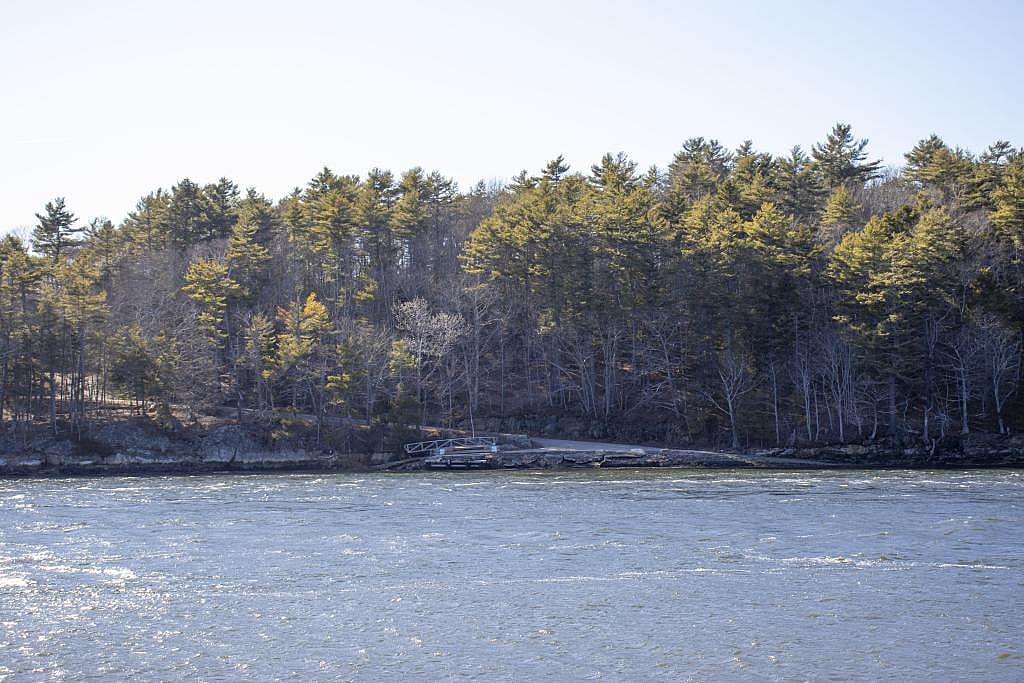 As seen from across the Back River in April of 2026, the 300-acre site where the idea for a data center was made public last fall remains undeveloped in Wiscasset, Maine.