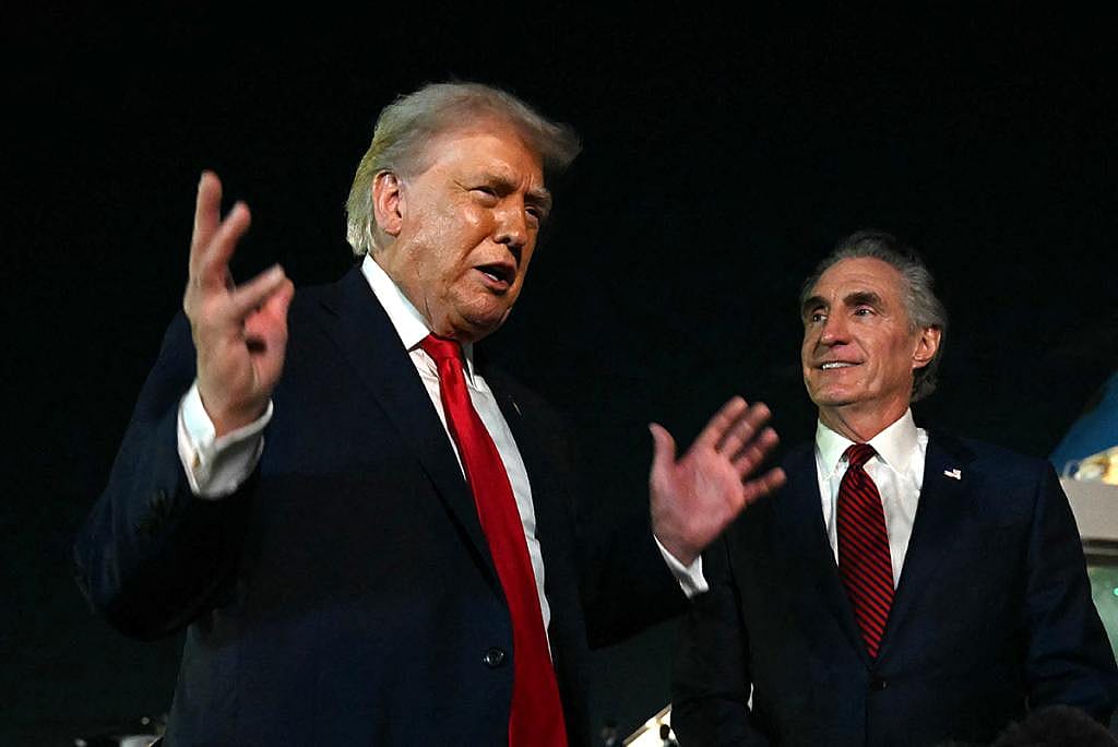 US President Donald Trump speaks with reporters as the Secretary of the Interior Doug Burgum (R) looks on, before boarding Air Force One at Palm Beach International Airport, in West Palm Beach, Florida on January 19, 2026. 