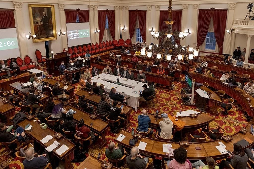 A farm worker leader testifies to a committee of Vermont legislators through an interpreter at a public hearing at the Vermont state capitol in March after protesters clashed with ICE.