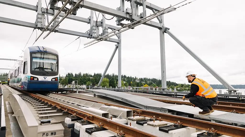 A worker crouches next to the tracks of a the $1 billion Crosslake Connection, an existing project that was behind schedule which Sound Transit aimed to finish before the world cup.