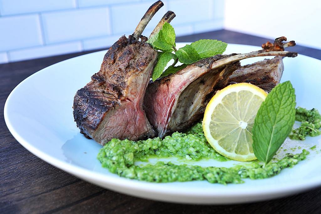 A plate of grilled lamb with pea and mind pesto.