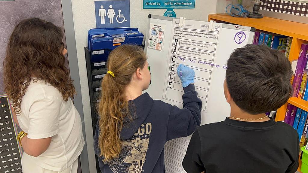 Third grade students Taylor Butters, Claire Stewart and Kane Teran work together during a reading and writing activity at Windsor Park Elementary.