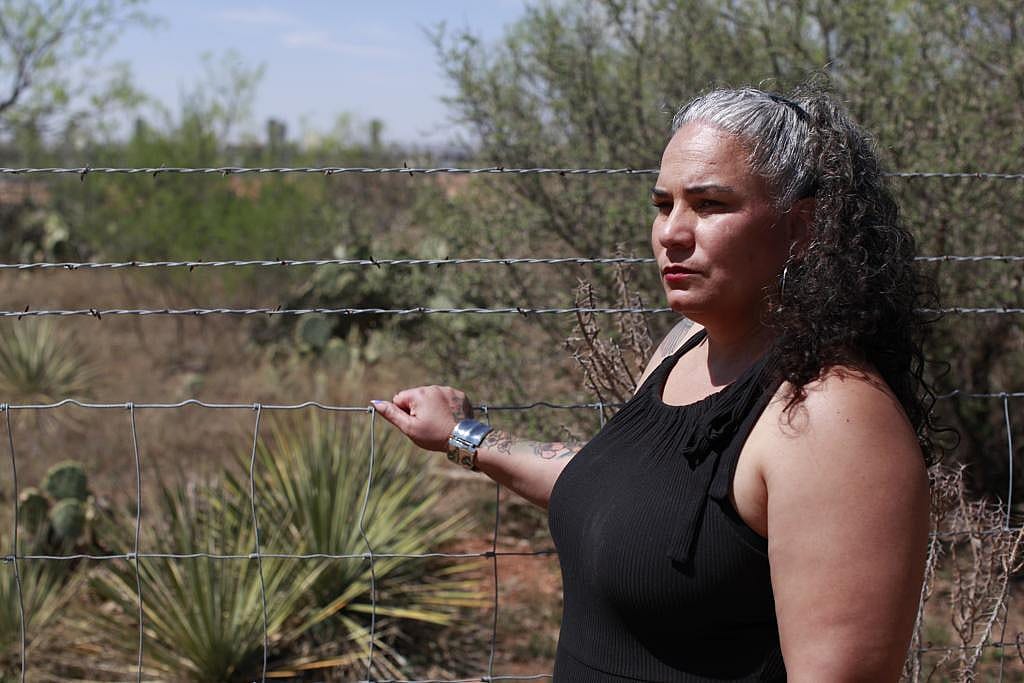 Omaira Garcia standing next to a fence on her property in Abilene, Texas.
