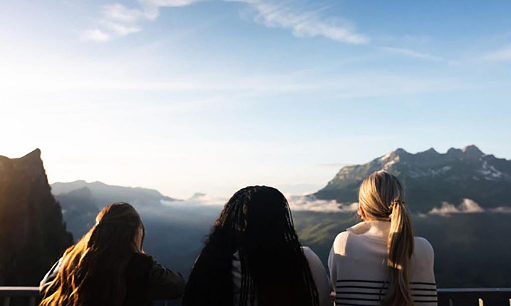 A group of friends overlooking the Swiss Alps.