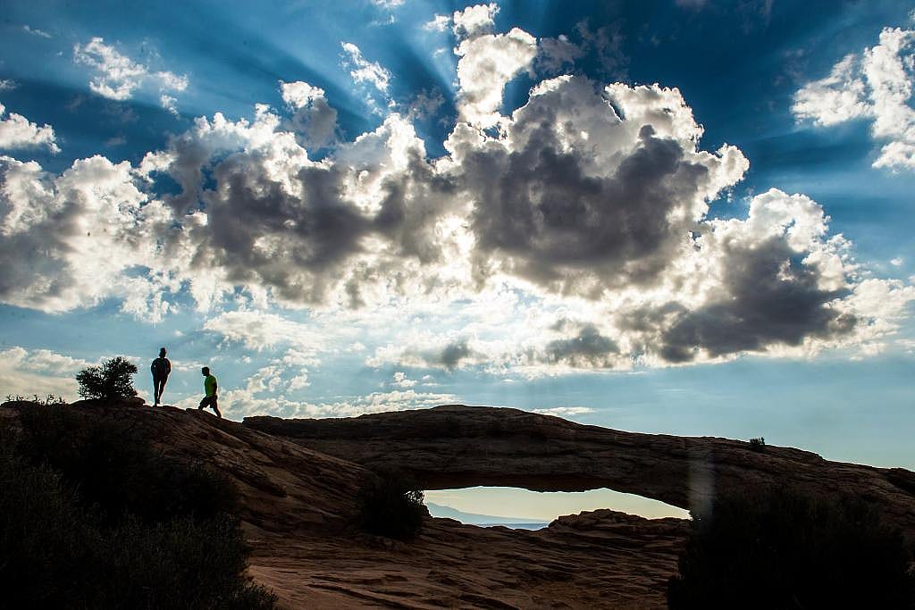 Visitors walk around Mesa Arch in the Island in the Sky District at Canyonlands National Park Thursday August 25, 2016.