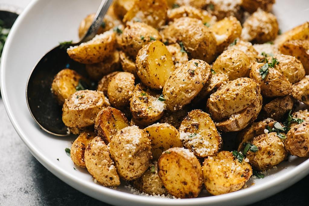 Parmesan garlic and grilled Yukon potatoes served in a plating dish.