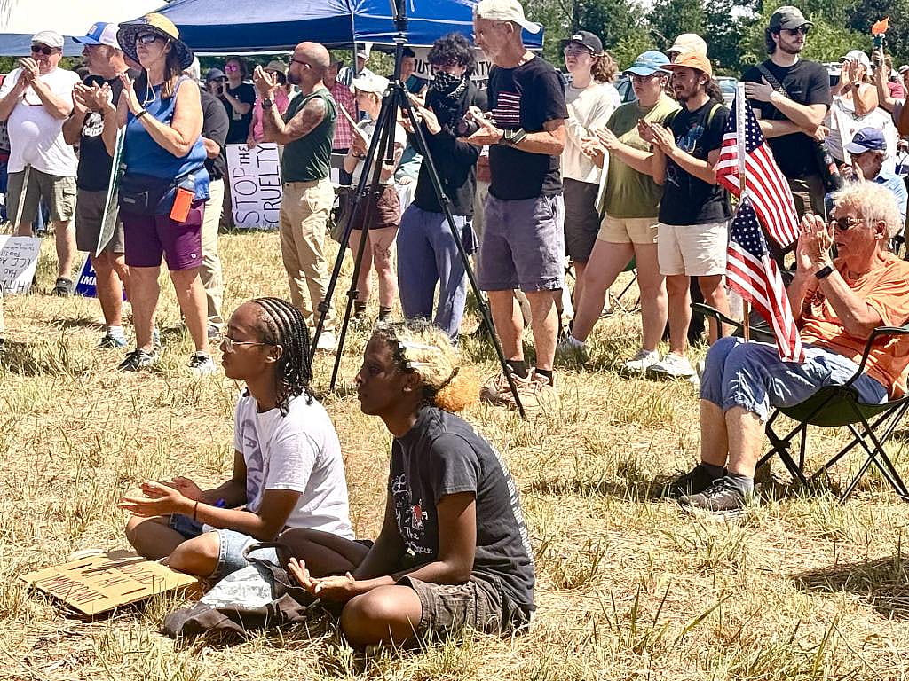 Rallygoers listen to speakers at a private lot within eyeshot an ICE detention facility for migrants established last year in McCook.