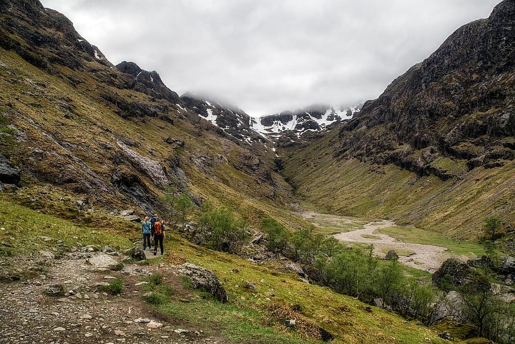 Hikers walking along the Lost Valley trail in Glen Coe, in the highlands of Scotland.