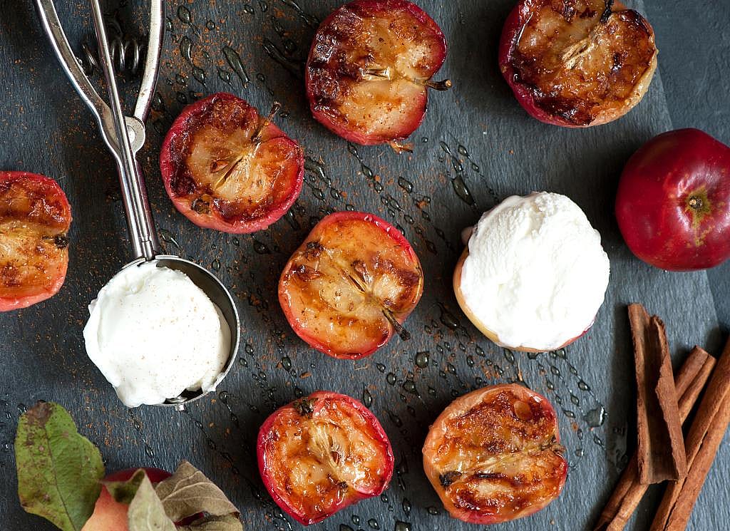 Baked apples with vanilla ice cream scoops.