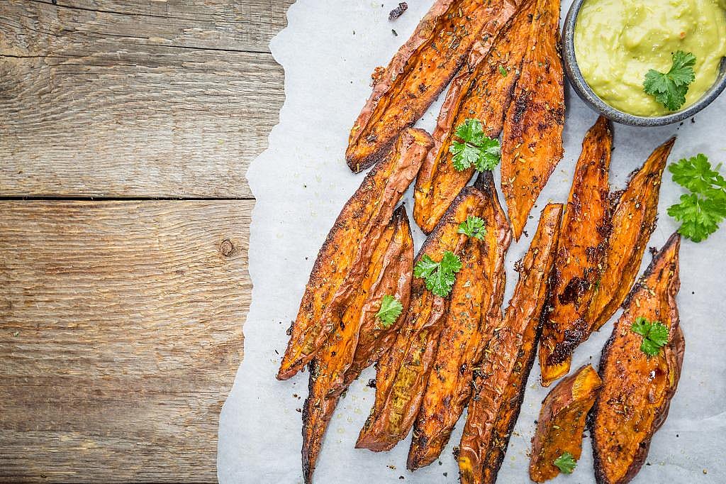 A tray of roasted sweet potato with herbs.