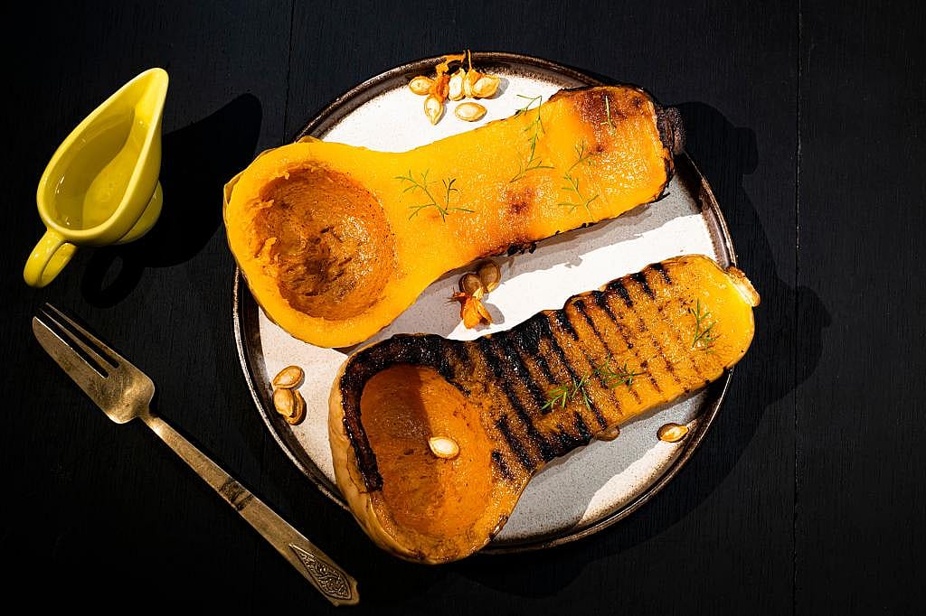 A plate of grilled butternut squash with herbs.