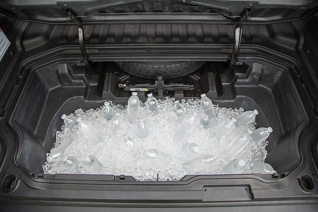 2026 Honda Ridgeline in-bed trunk filled with ice and bottles of water.