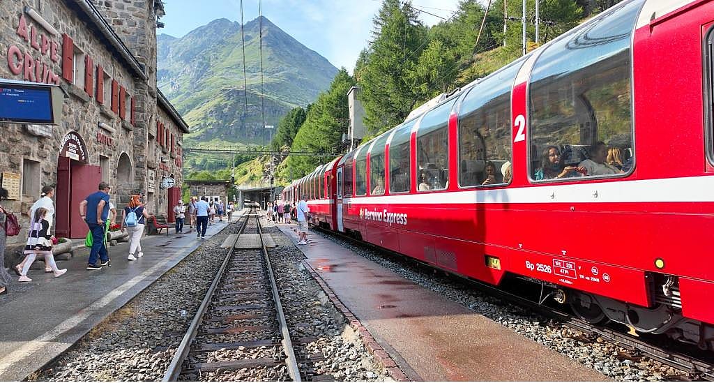 Tourists exploring the UNESCO-listed Rhaetian Railway in the mountainous terrain of Switzerland.