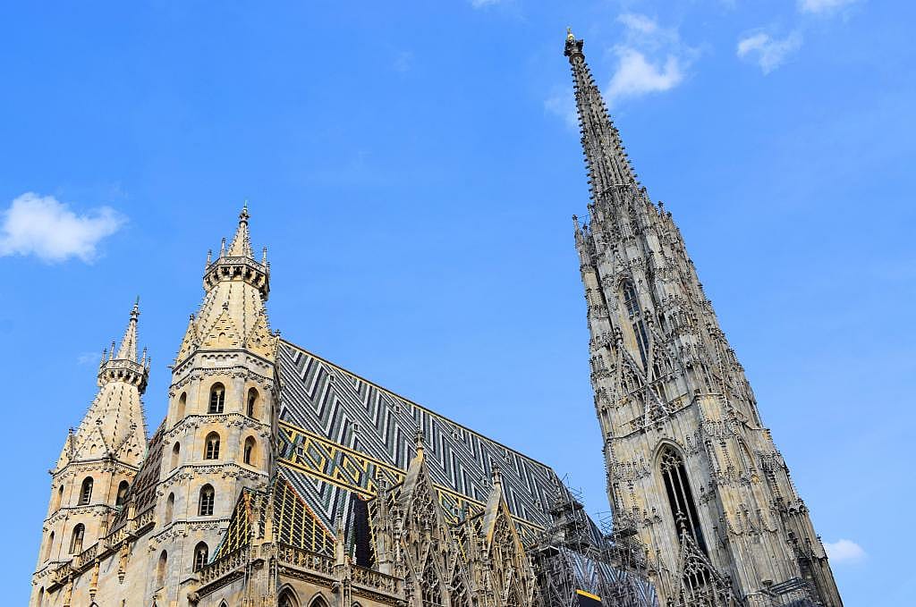 An outside view of the multicolored roofs and towers of the St. Stephen's Cathedral in Vienna, Austria.