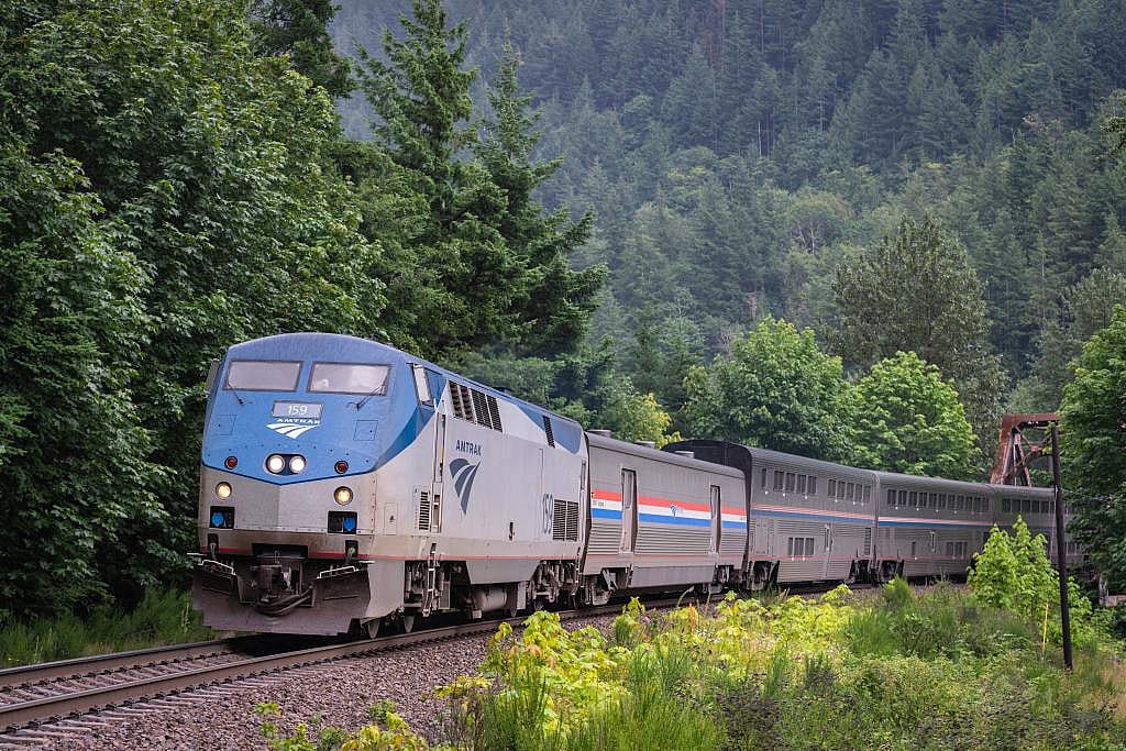 Amtrak's Empire Builder overnight passenger train passing through the Cascade Mountains in Index, Washington, USA.