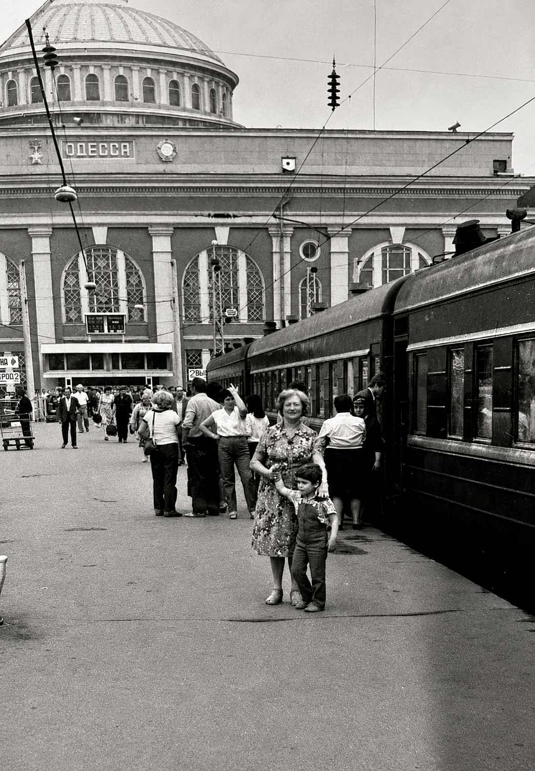 Little boy and his grandma at a train station.
