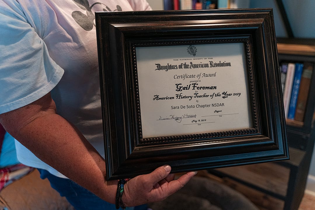 A person holds a framed certificate.