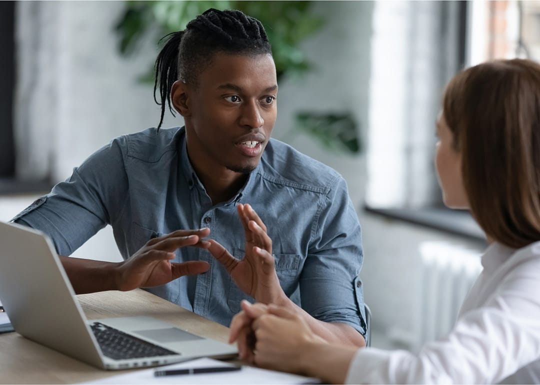 Black team leader discusses with coworker