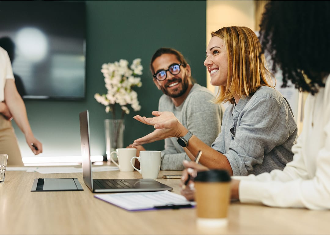 Cheerful businesswoman has discussion colleagues.