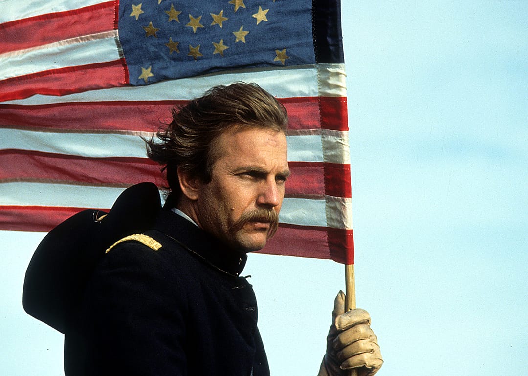 Kevin Costner holding an American flag in a scene from 'Dances With Wolves’.