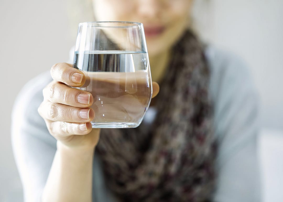 Woman holding glass of water