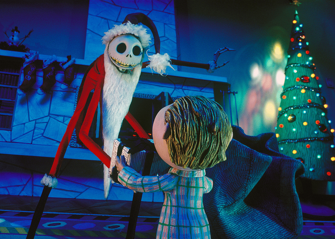Still frame from ‘A Nightmare Before Christmas’ with Jack Skellington dressed as Sandy Claws handing a gift to a child.