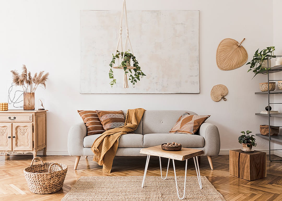 A living room with a boho, but minimalist style with mostly white and neutral colors. 