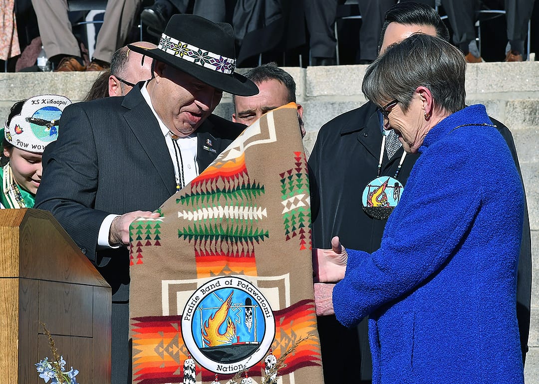 Kansas governor Laura Kelly is presented with a ceremonial blanket by members of the Prairie Band Of The Potawatomi Nation.