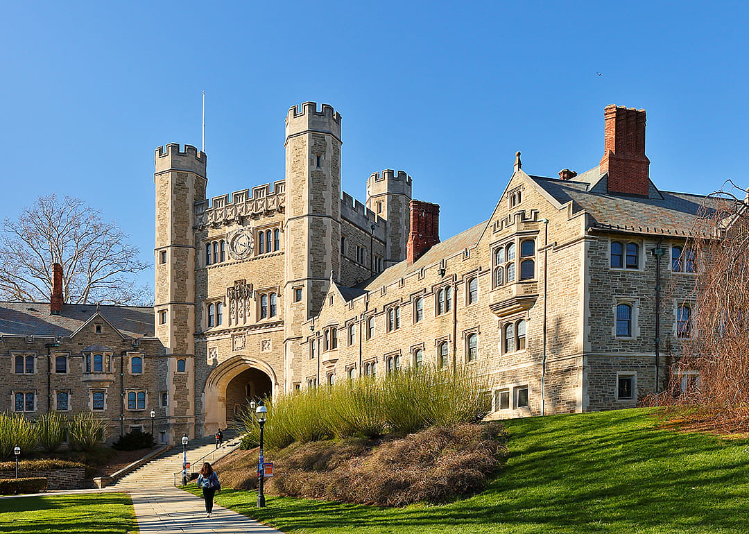 A couple of students walk on a mostly empty Princeton campus.