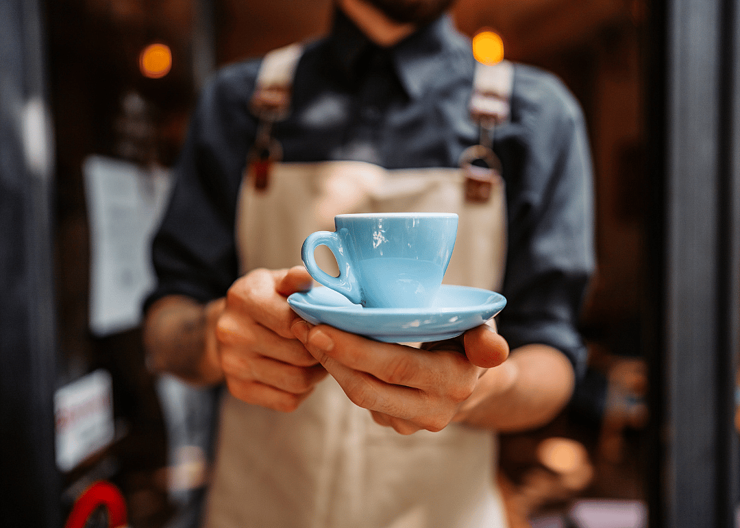 Barista presenting espresso drink.