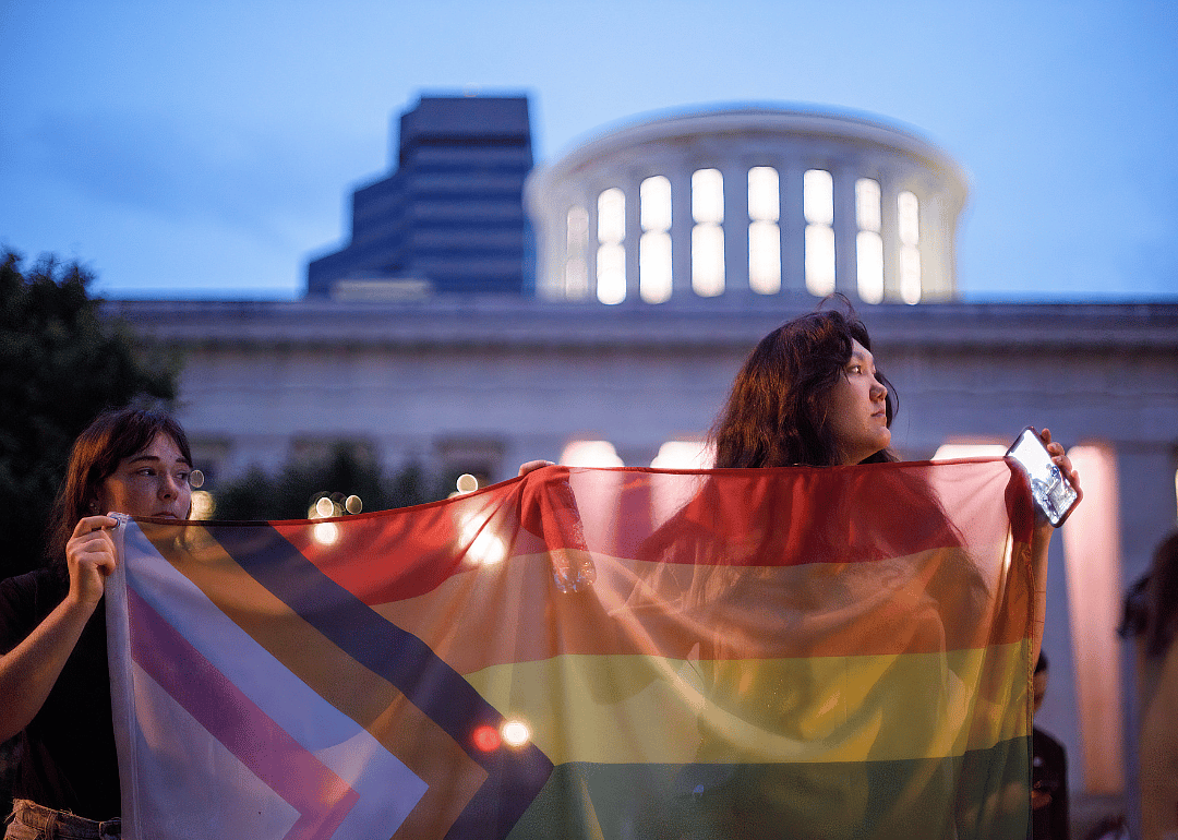 Transgender rights advocates holding a pride flag outside the Ohio Statehouse.