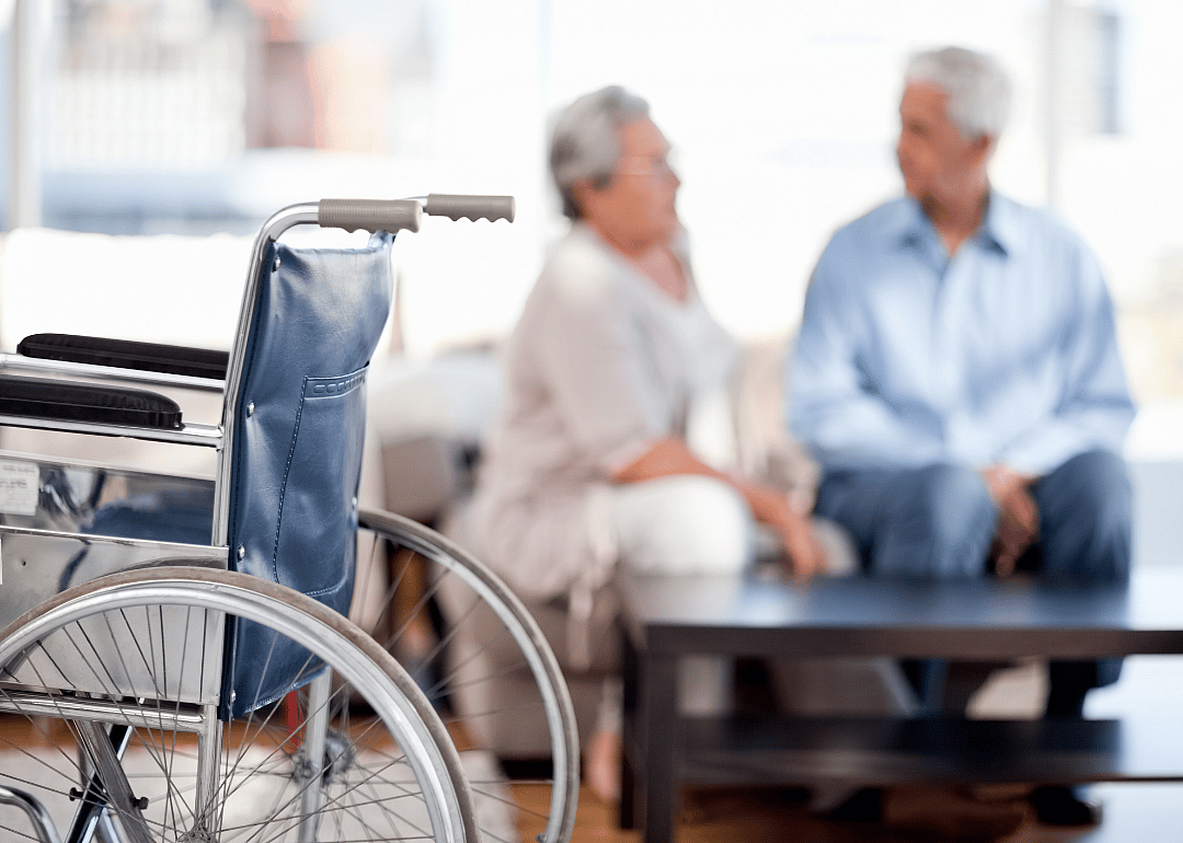 Wheelchair with couple talking in background.