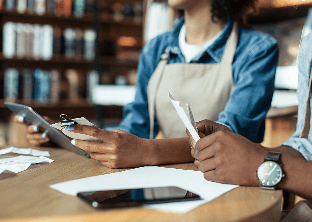 Small business owner and bookkeeper managing records.