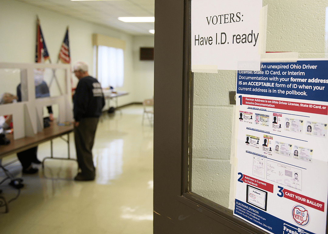 A voter shows identification to an election judge during primary voting in Ohio.