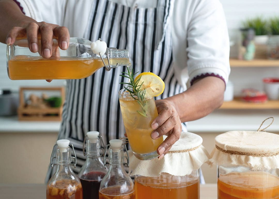 Person preparing kombucha drinks.